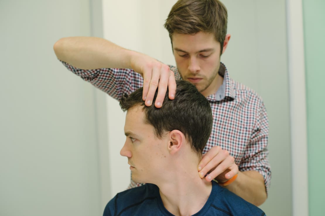 clinician assessing a patient's neck