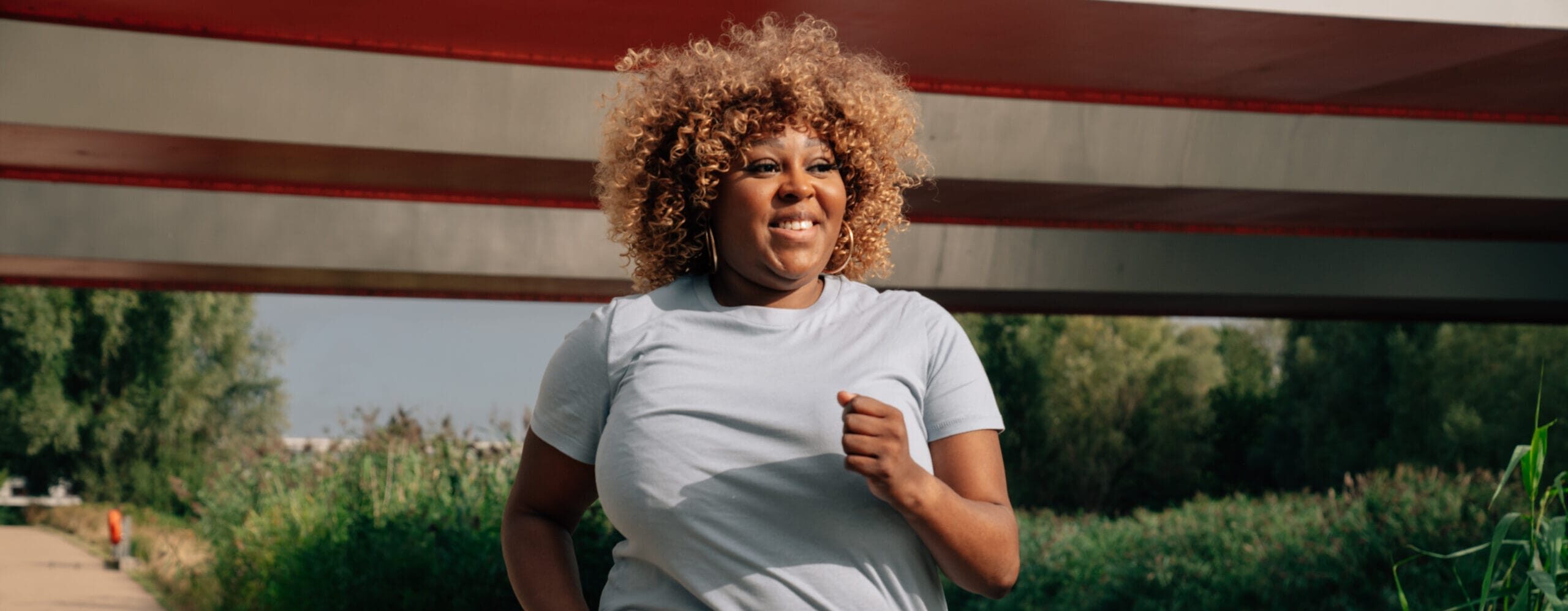 a woman running under a bridge