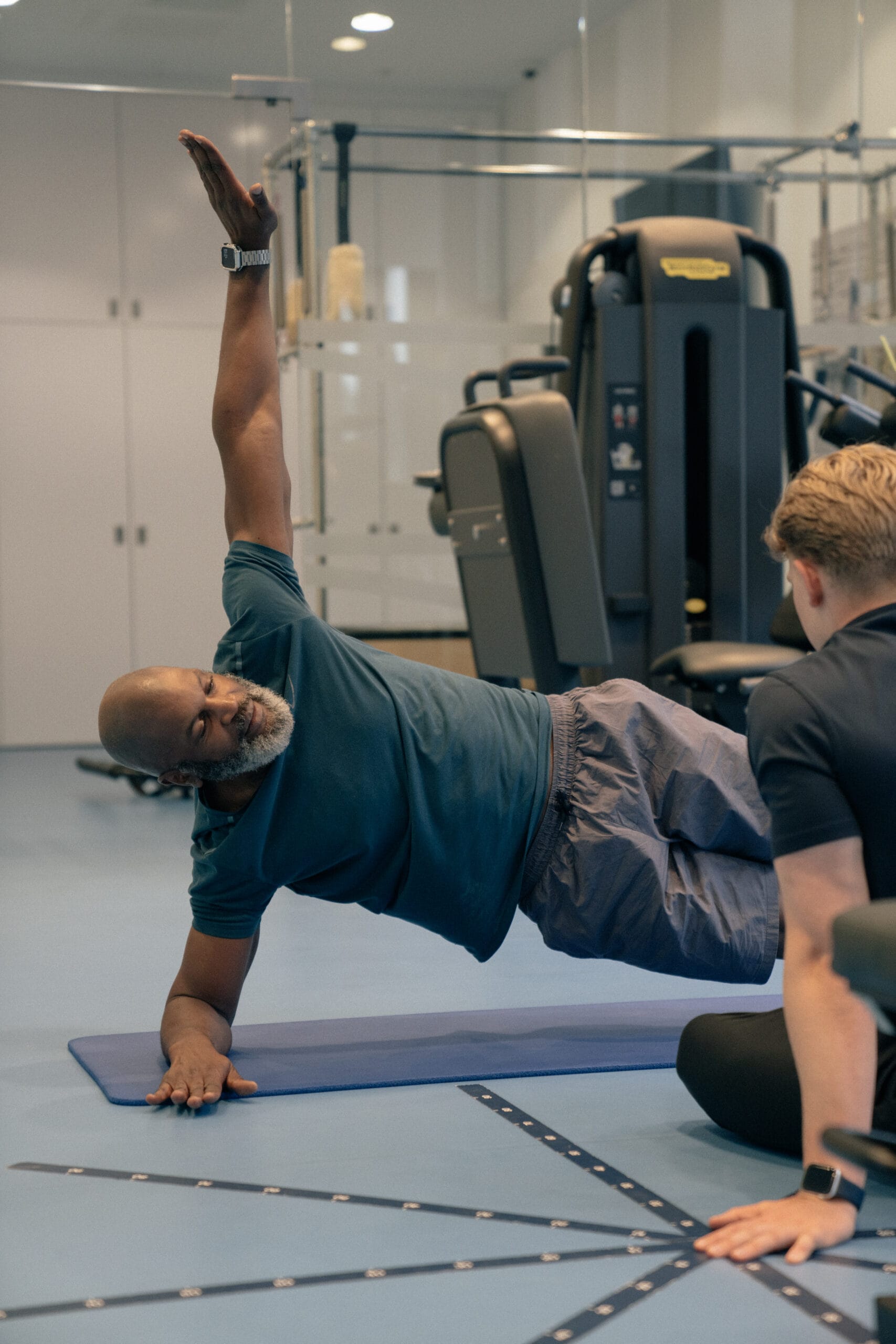 man holding a side plank on a mat