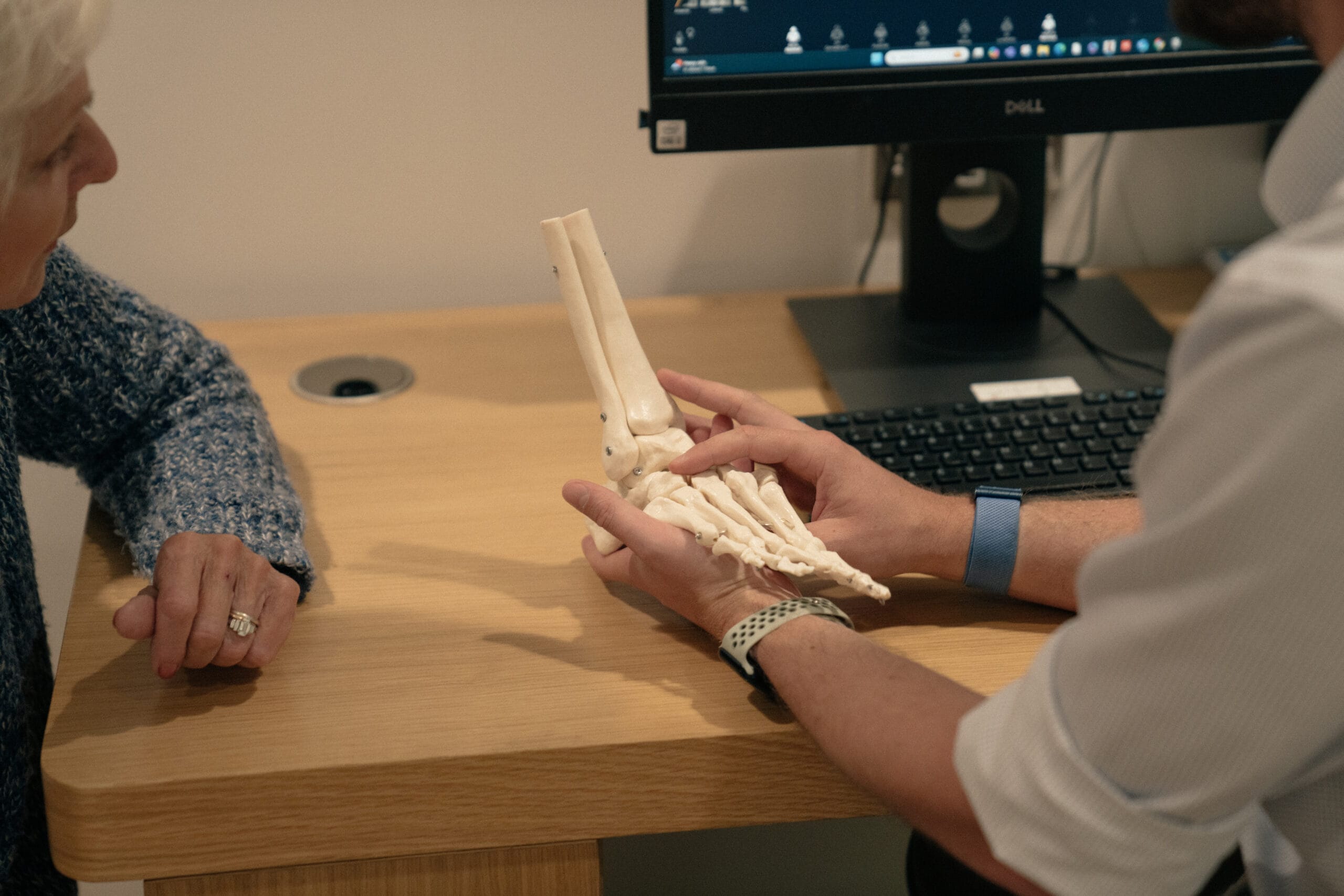 Clinician demonstrating on medical model of foot for podiatry advice