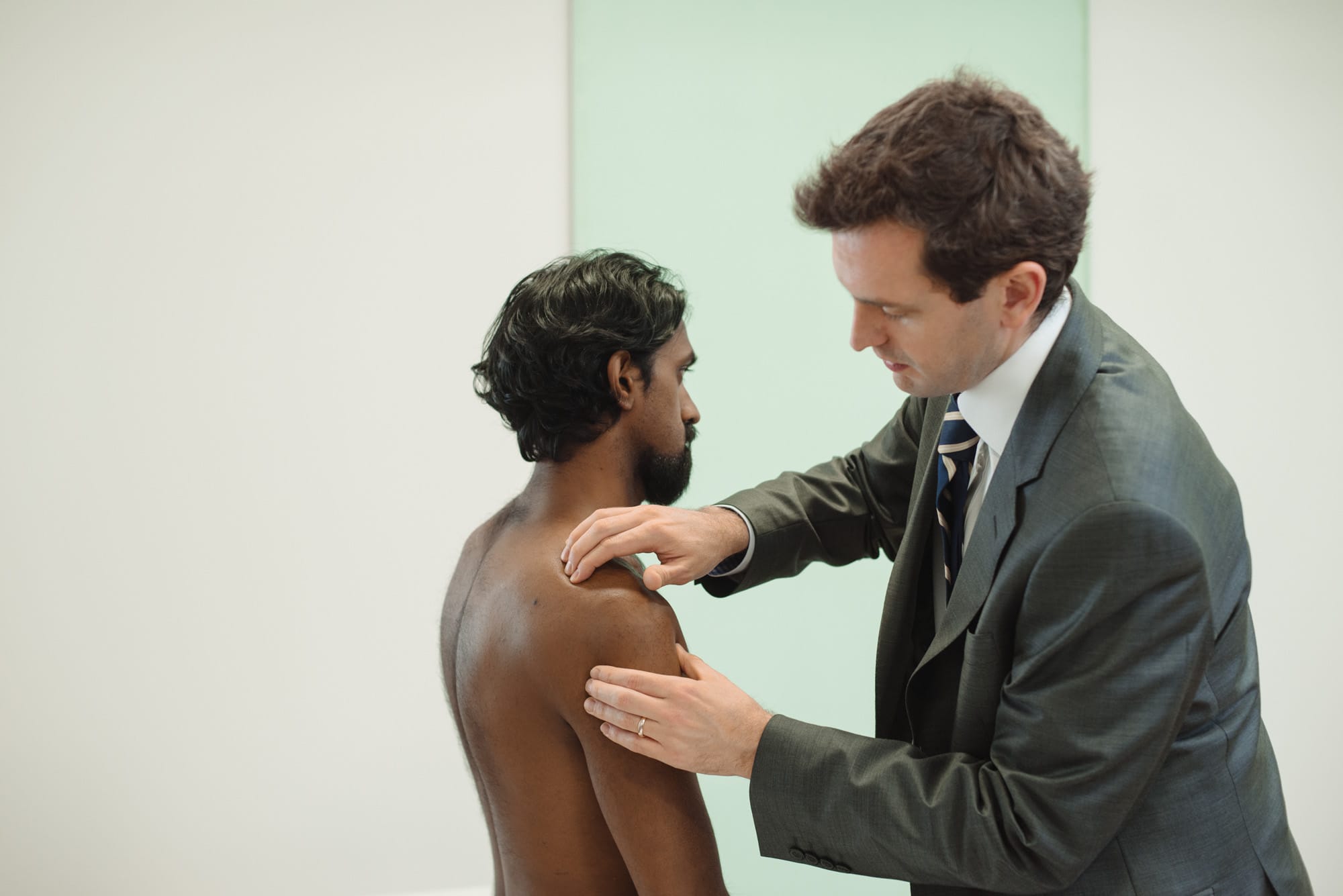 Clinician assessing patient's shoulder
