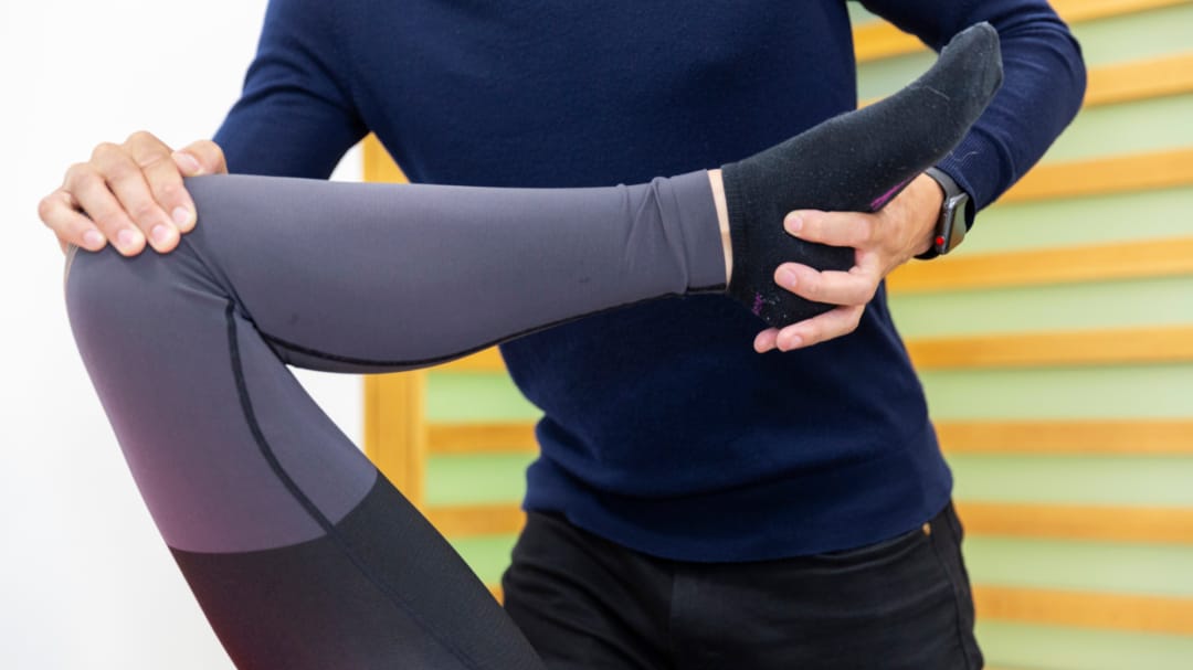 clinician stretching patient's leg