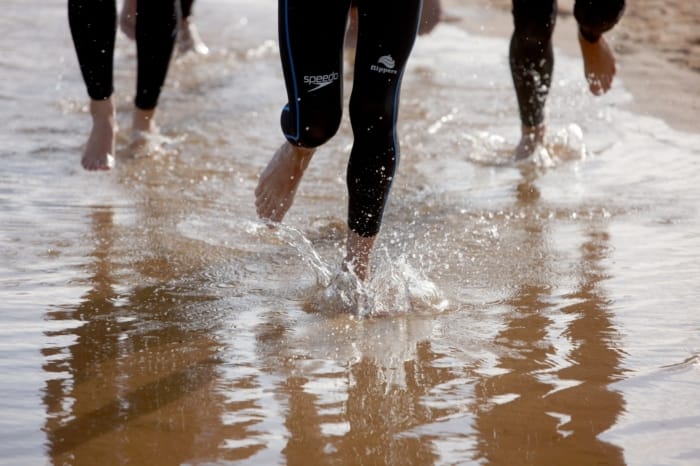 close up of feet running in shallow water on the beach