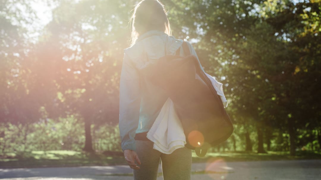 woman with gym bag outside