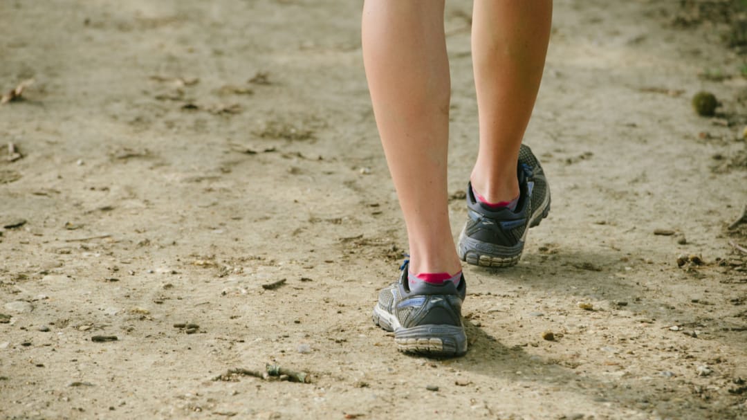 Feet in trainers walking on the ground