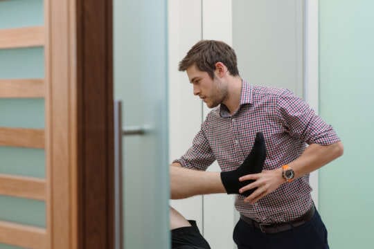 physiotherapist holding patients foot in appointment room