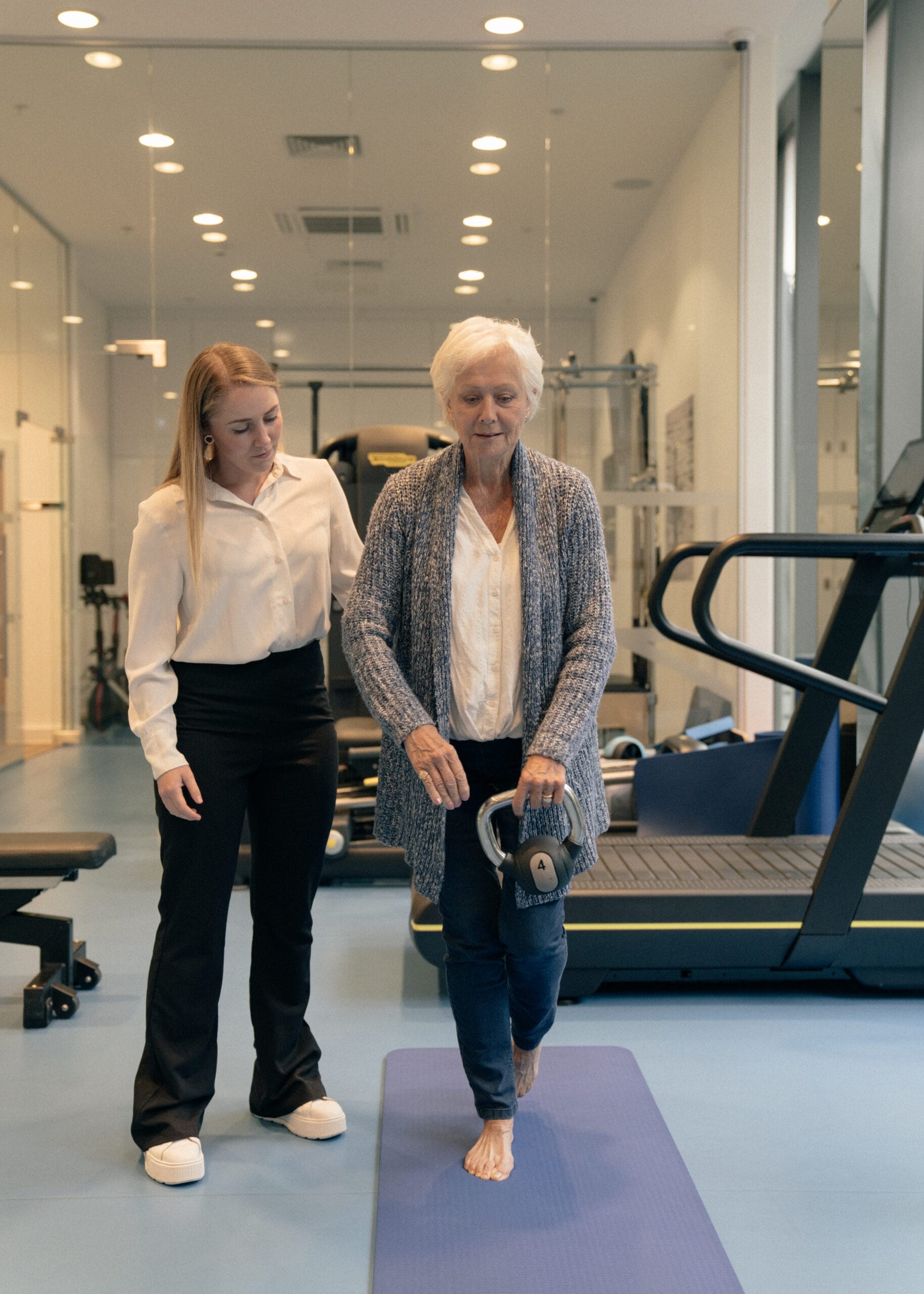 Musculoskeletal physiotherapist and older patient in gym