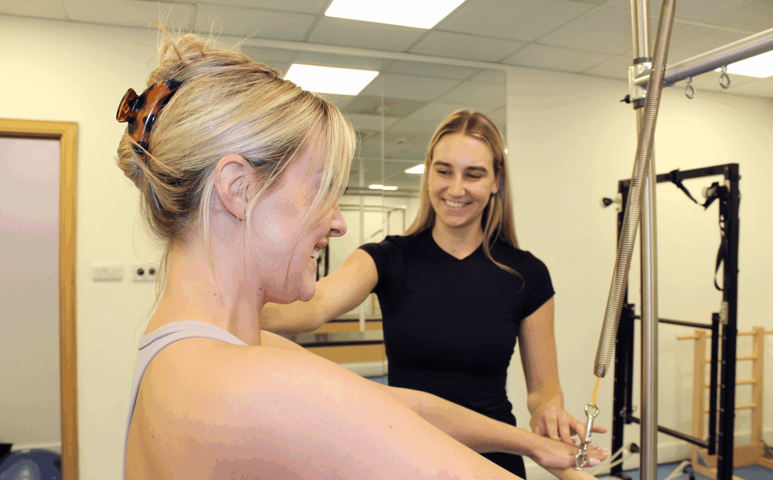 clinician smiling at patient in Pilates