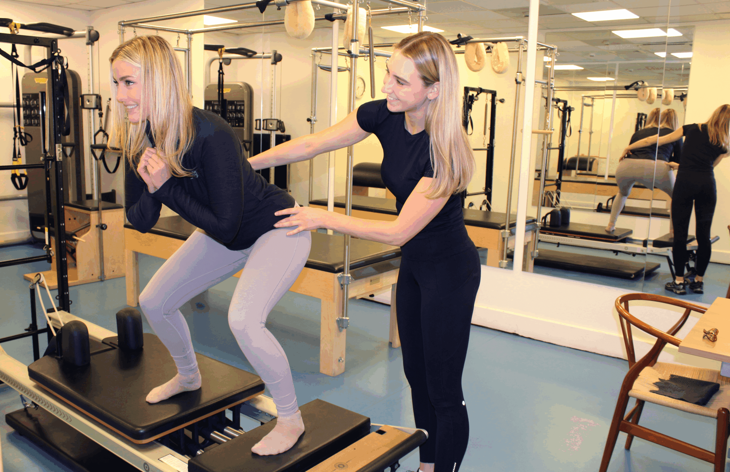 clinician supporting woman squatting on bench