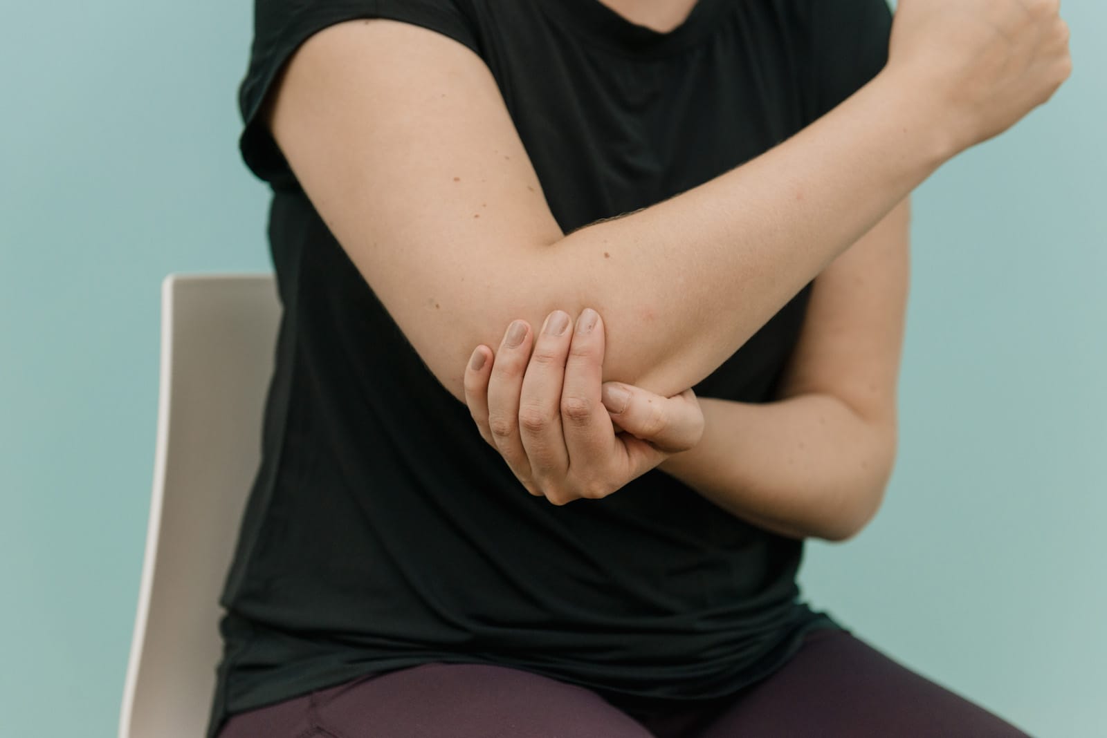 person holding elbow sat down